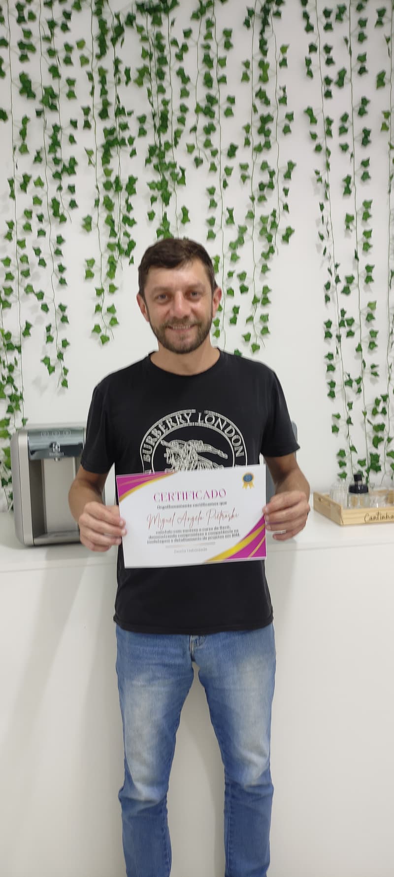 Miguel segurando certificado de conclusão da Escola Habilidade em São José SC