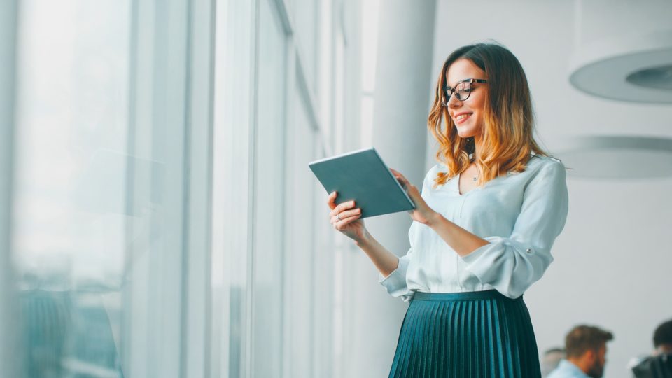 Profissional em escritório com tablet, representando a formação Do financeiro à gestão da Escola Habilidade